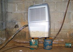A dehumidifier that shows signs of being half-submerged in water in a crawl space in the past.