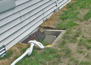 The ugly, old concrete window well of a Burlington crawl space