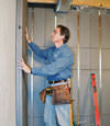 Insulated basement wall panels being placed against a concrete foundation wall in Brantford